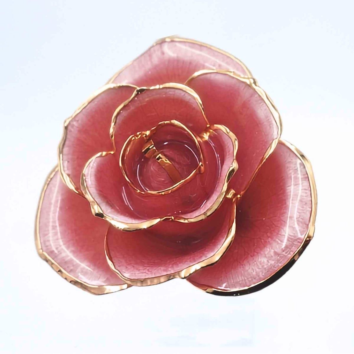 A rose-shaped brooch featuring glossy pink petals with polished gold-tone metallic edges, shown on a plain light background.