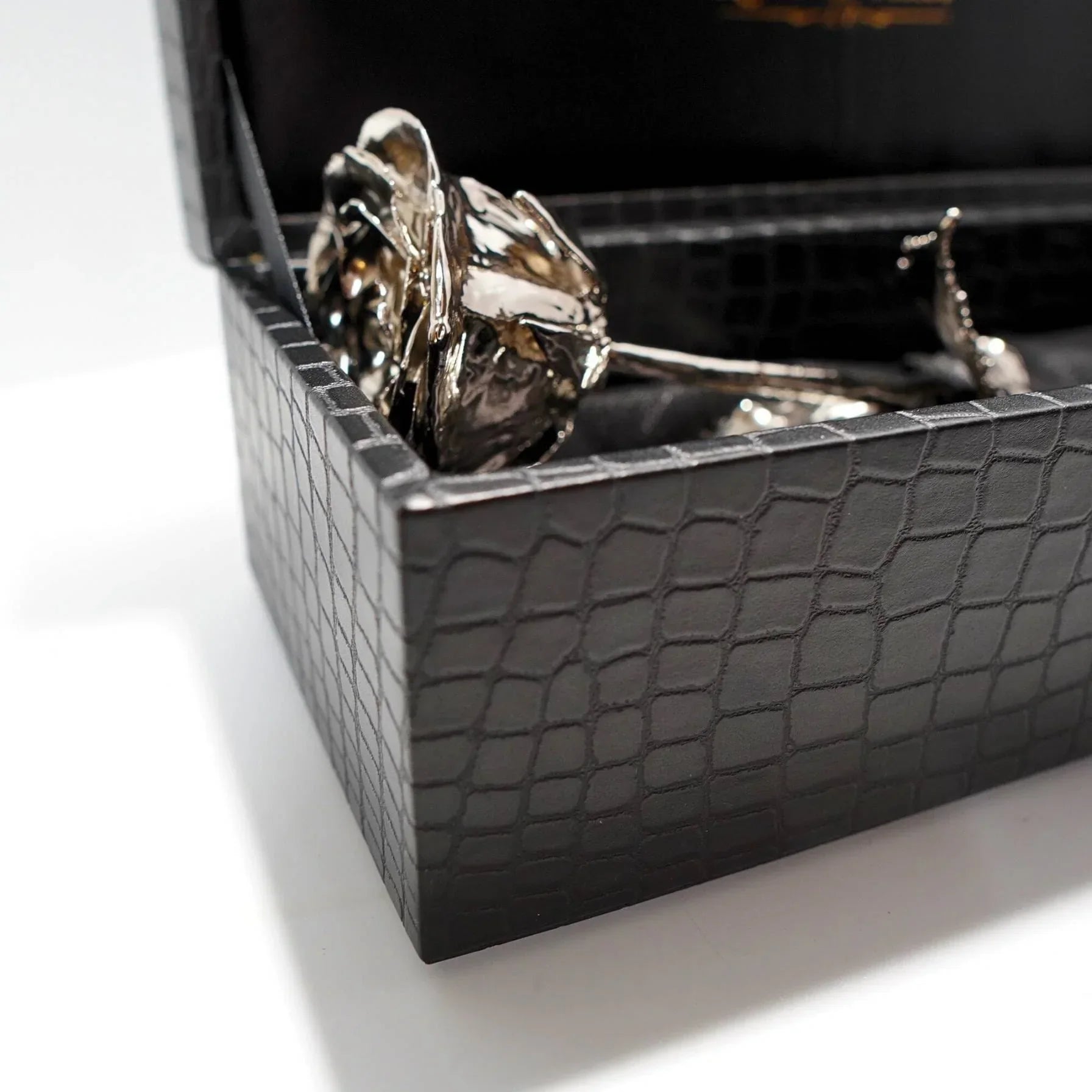 platinum dipped gold rose in a black textured box on a white background