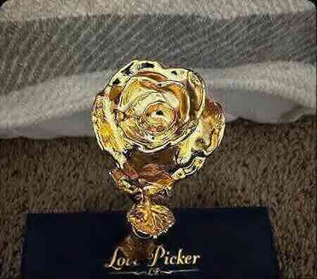 Gold rose-shaped trophy with 'Love Picker' branding on a striped background