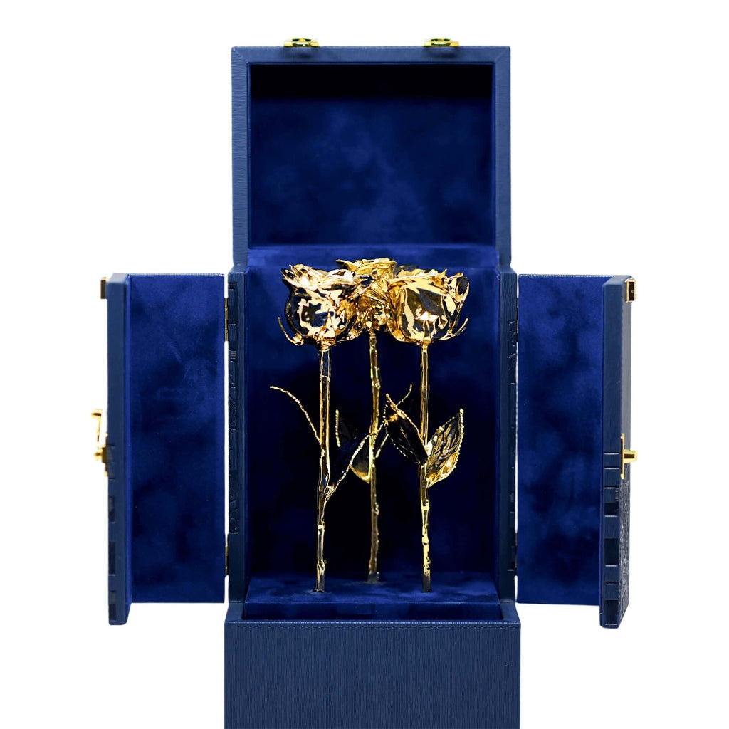 Gold rose in a blue jewelry box on a white background