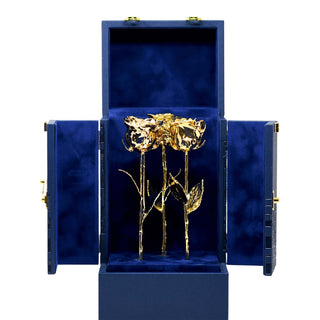 Gold rose in a blue jewelry box on a white background