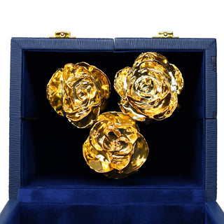 Three gold roses in a blue box on a white background