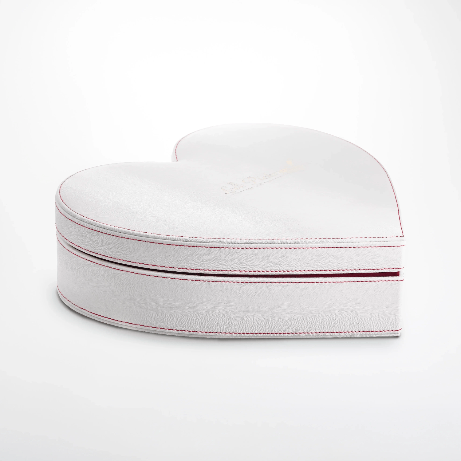 White heart-shaped gift box with red stitching on a plain background