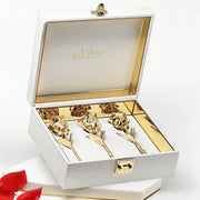 Three gold preserved roses in an elegant white gift box with gold interior and clasp.