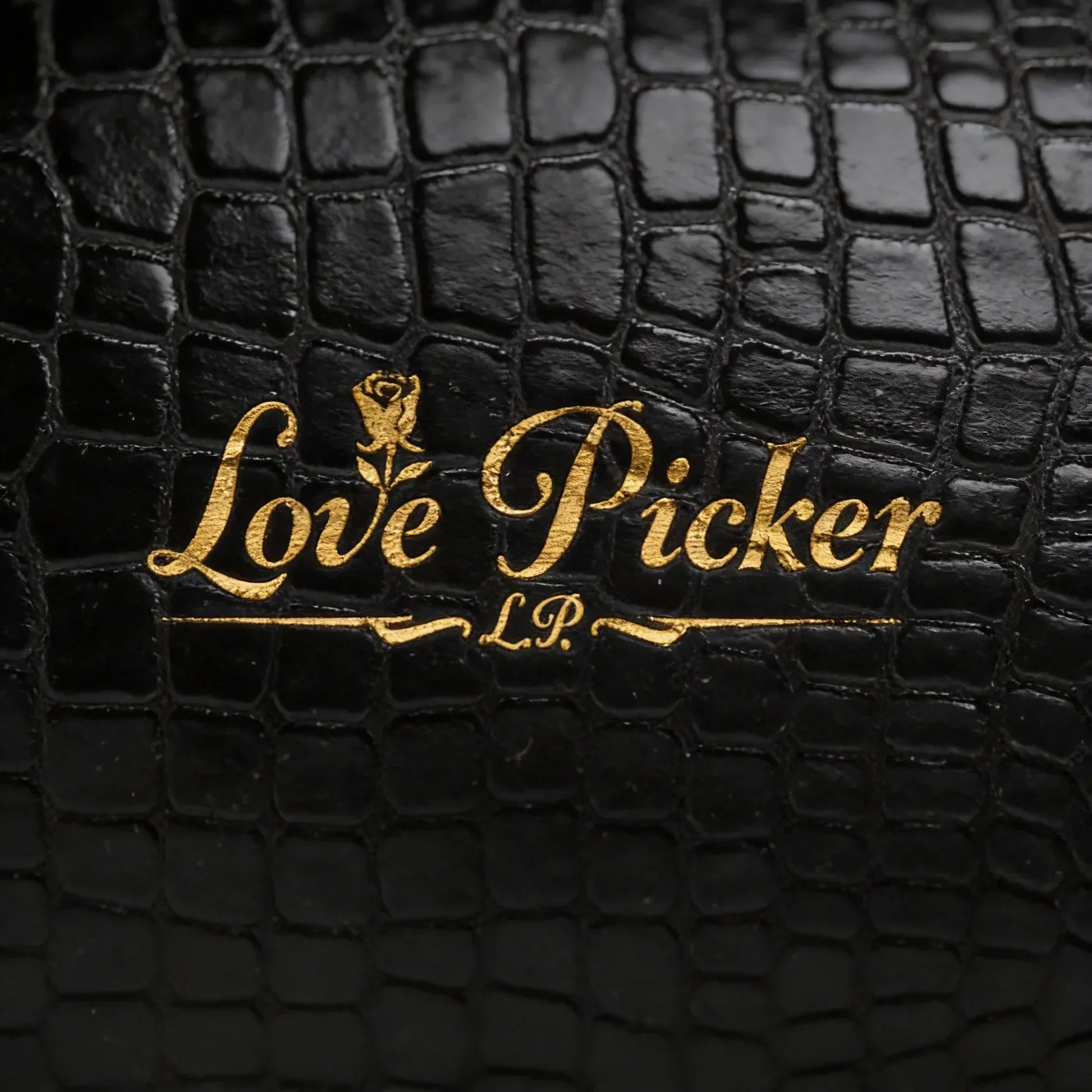 Gold Love Picker logo on black textured faux leather background, luxury gift packaging