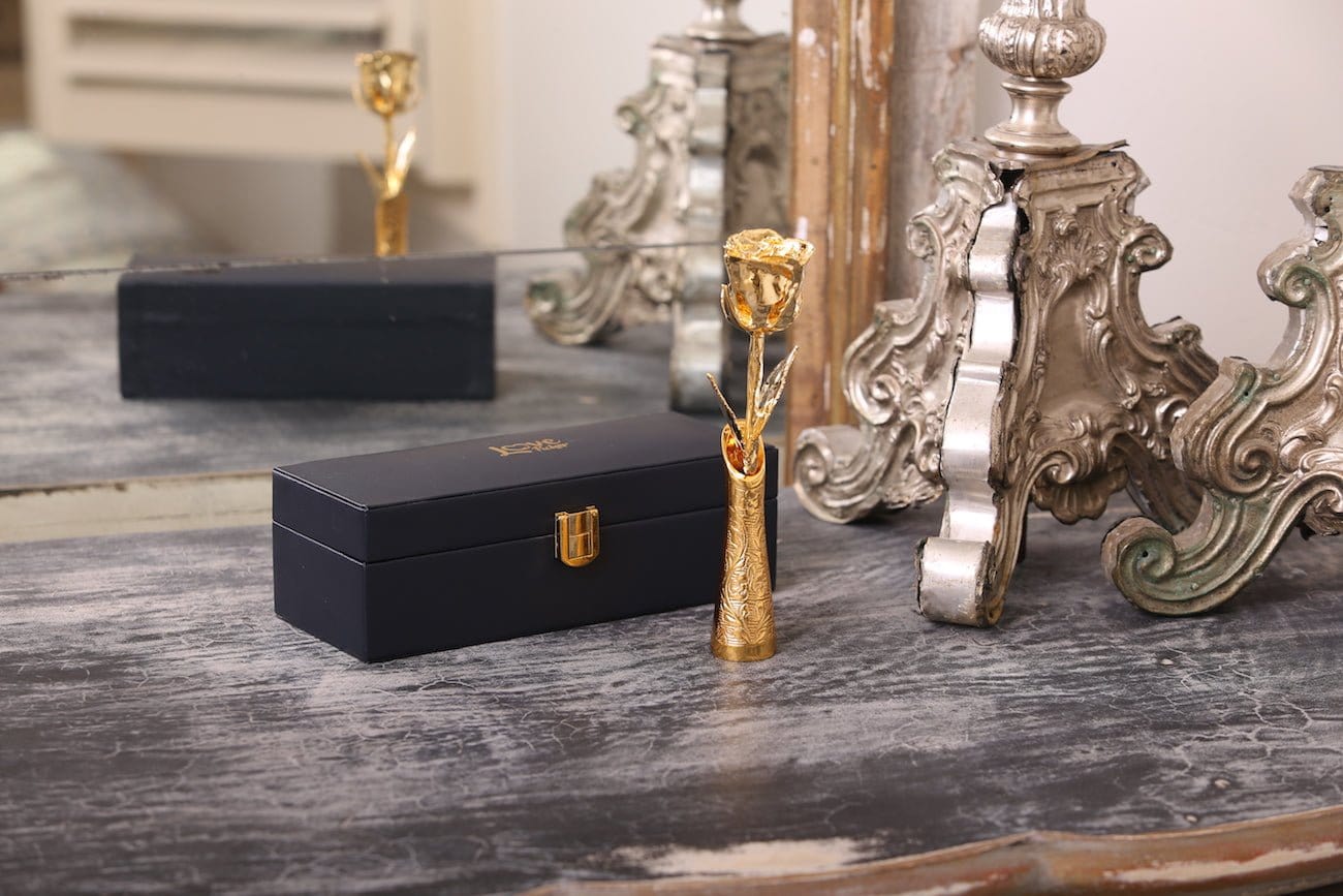 Lovepicker 24k gold rose vase holder displayed on rustic wooden table with decorative mirror background